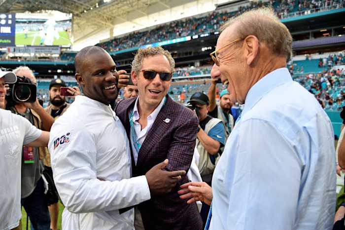 Coach Brian Flores is congratulated by Dolphins owner Steve Ross after his first win for Miami against the Jets.